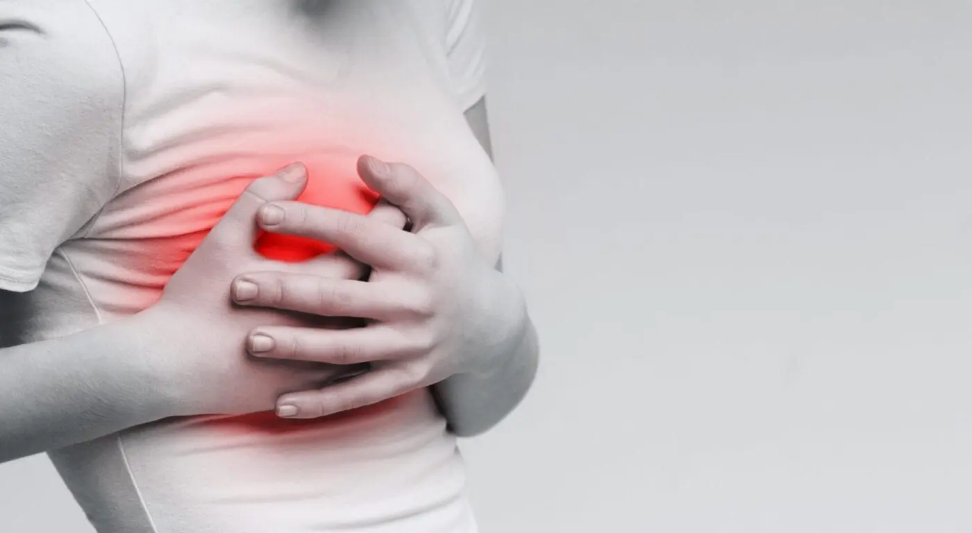 Breast pain. Woman suffering from painful feelings, clutching her boob, monochrome photo with red spot, panorama